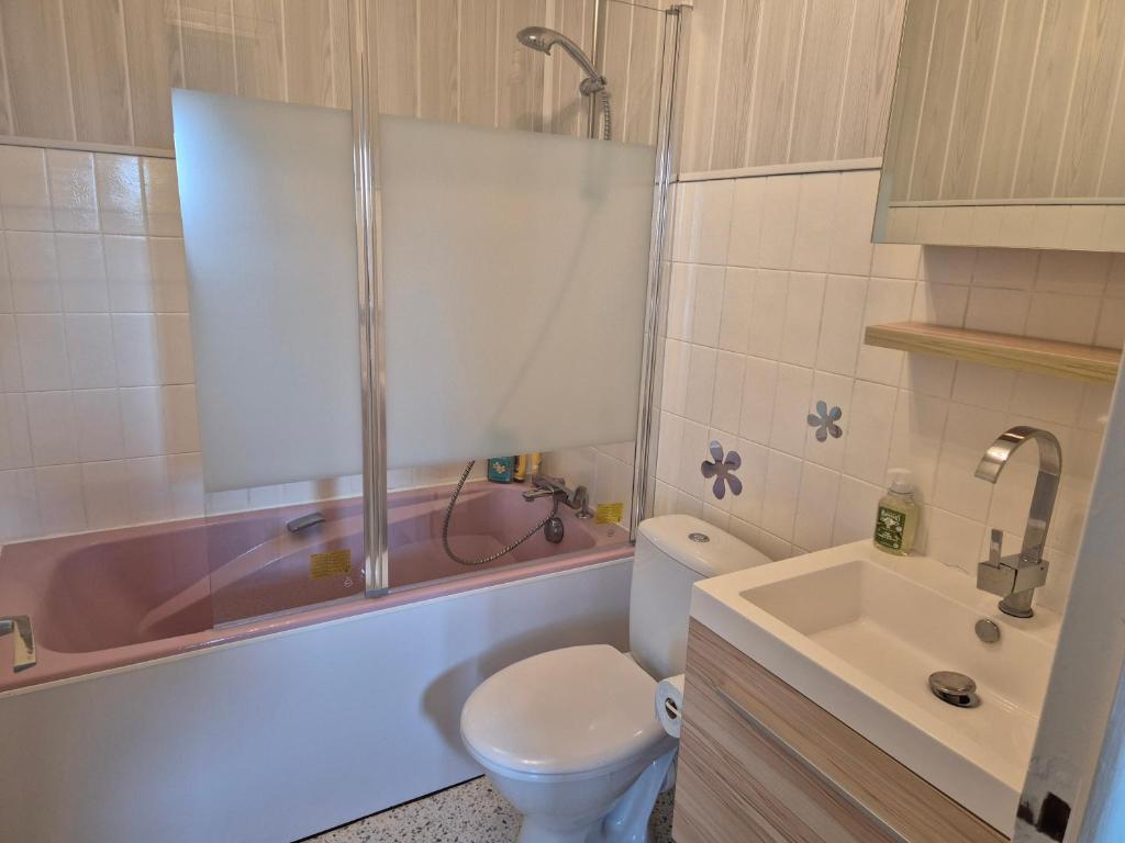 a bathroom with a tub and a toilet and a sink at L'ancre du Port in Saint-Quay-Portrieux