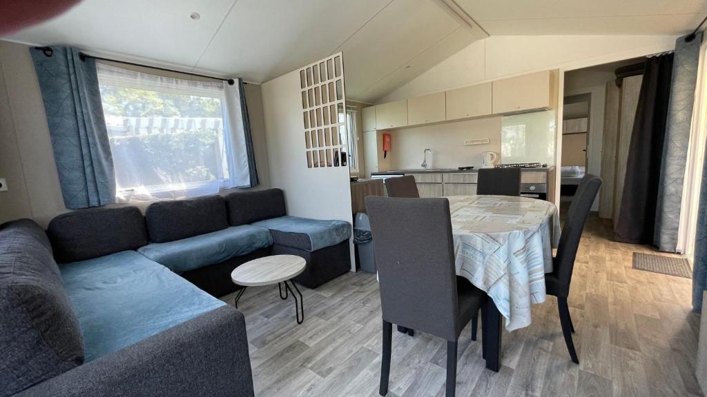 un salon avec un canapé et une table dans l'établissement Superb Mobilhome Cc379 Siblu Les Charmettes, aux Mathes