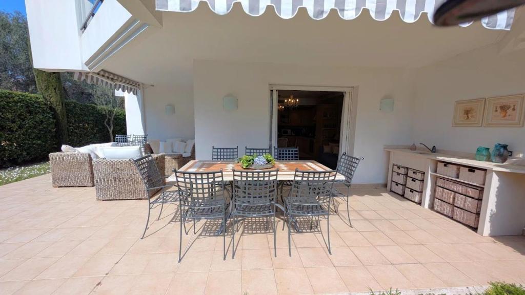 un patio avec une table et des chaises et une cuisine dans l'établissement Appartement avec terrasse au coeur de la nature, à Annonay