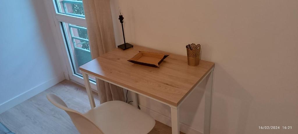 - un bureau avec un livre et une chaise dans la chambre dans l'établissement Studio Cosy centre Toulouse, à Toulouse