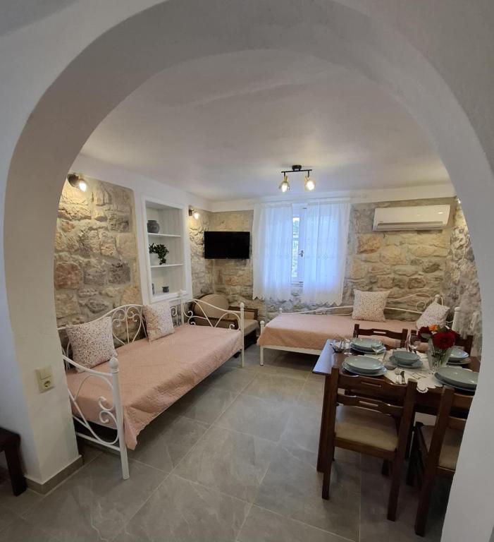 a living room with two beds and a table at Patriko Stone House in Fourka