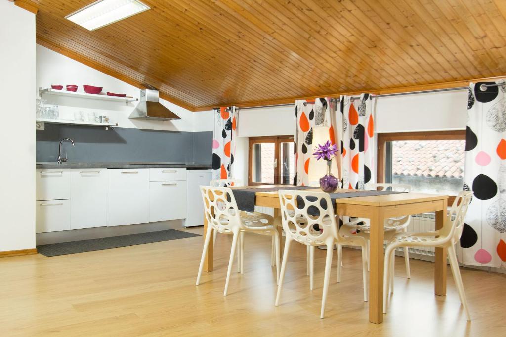 een keuken met een houten tafel en stoelen bij Apartment Bambola in Ajdovščina