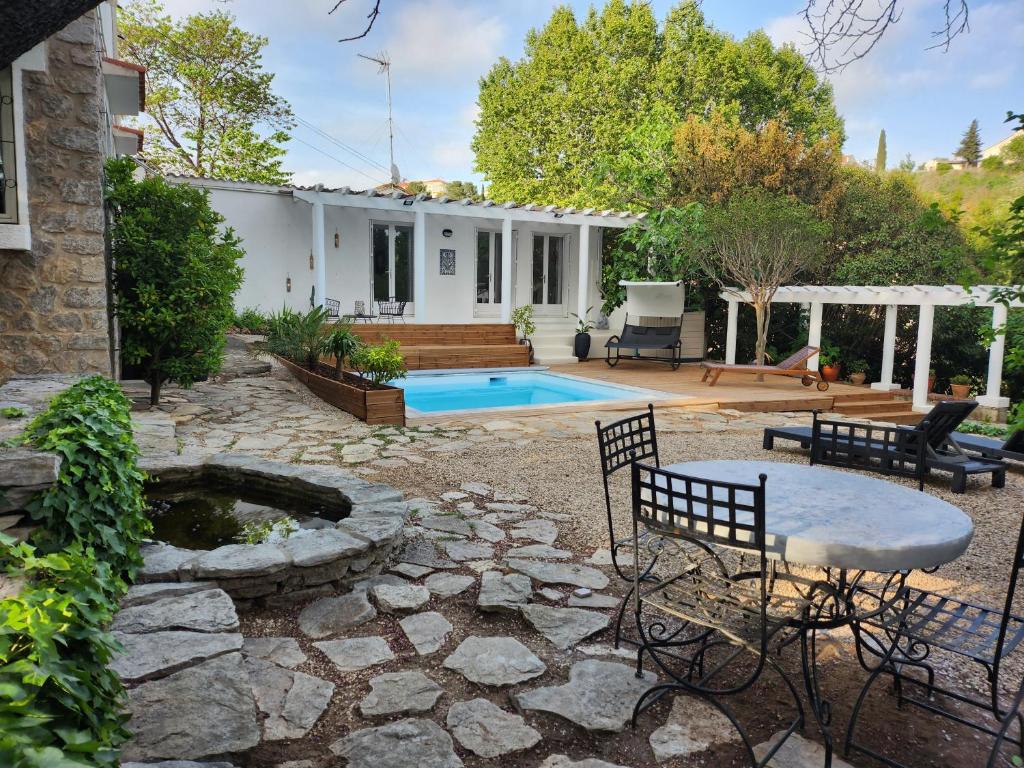 une cour arrière avec une piscine et une maison dans l'établissement Villa Jalna, à Béziers