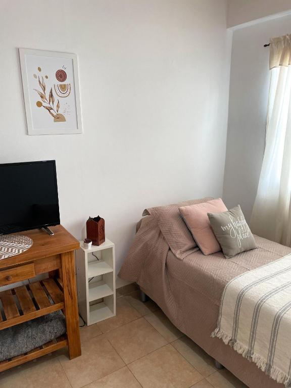 a bedroom with a bed and a desk with a computer at Habitación Independiente Azul in Azul