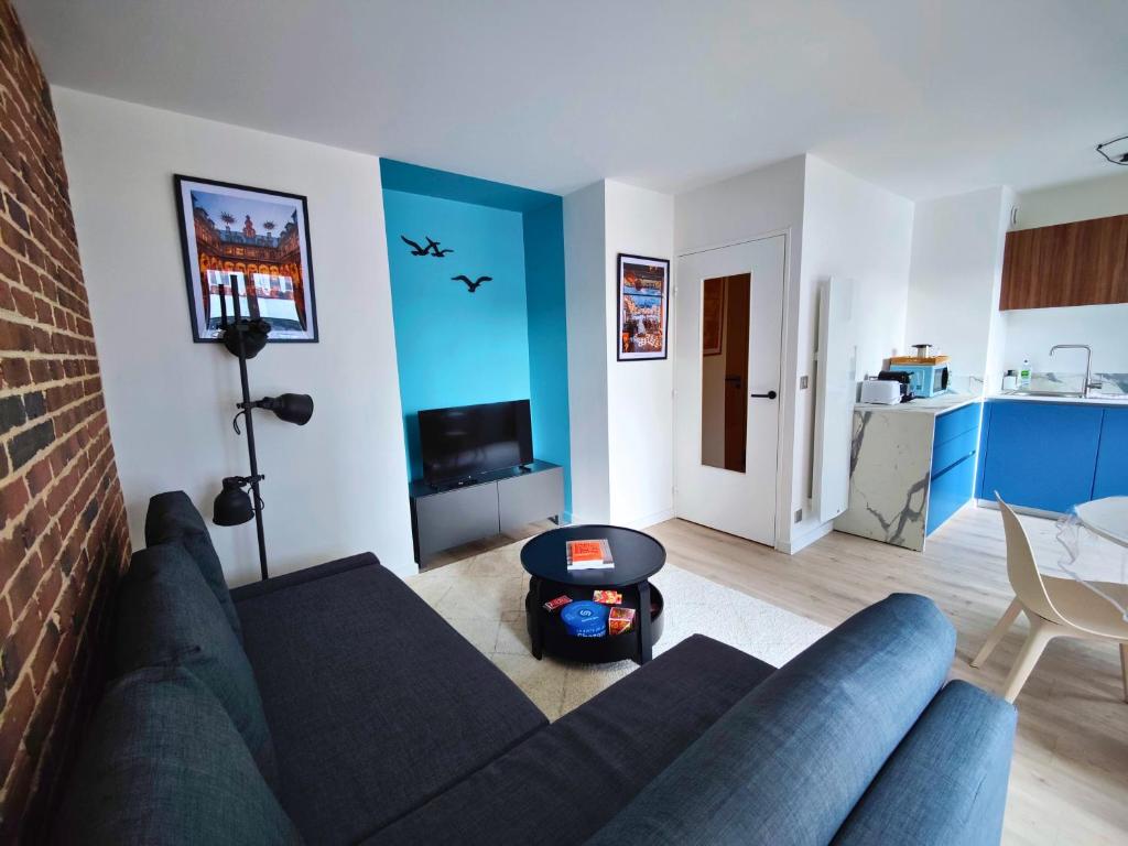 a living room with a couch and a table at La treille Vieux-Lille - 4 pers - Parking in Lille