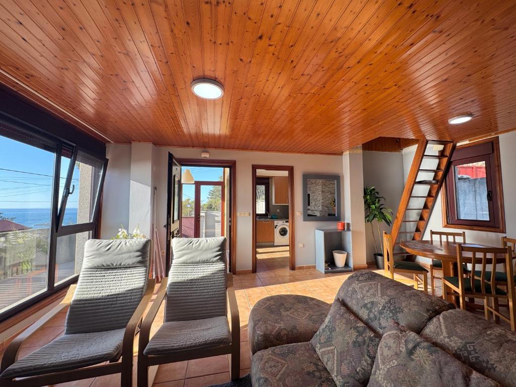 a living room with a couch and a wooden ceiling at ROOMS El Descanso del Peregrino por la Costa in Oia