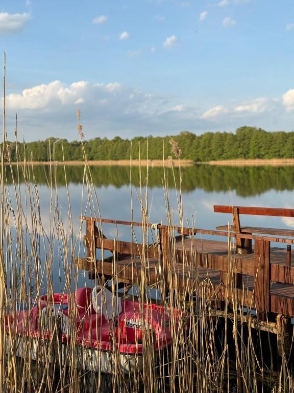 a boat sitting on the water next to a dock at Agroturystyka Parlińskie Wody I in Parlino