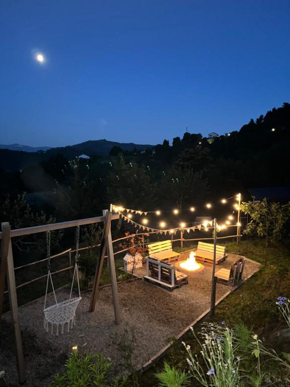 a patio with a swing and lights at night at Quinta da Lembrança in Arcos de Valdevez