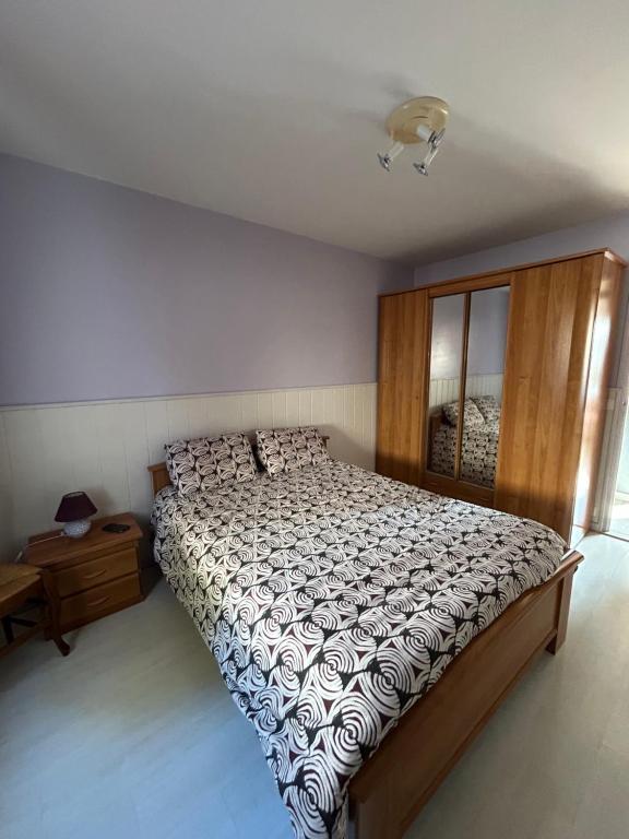 une chambre avec un grand lit et une commode dans l'établissement Maison dans village cotier, à La Celle-sous-Gouzon