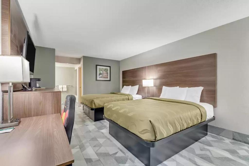 a hotel room with two beds and a television at Quality Inn in Dalton