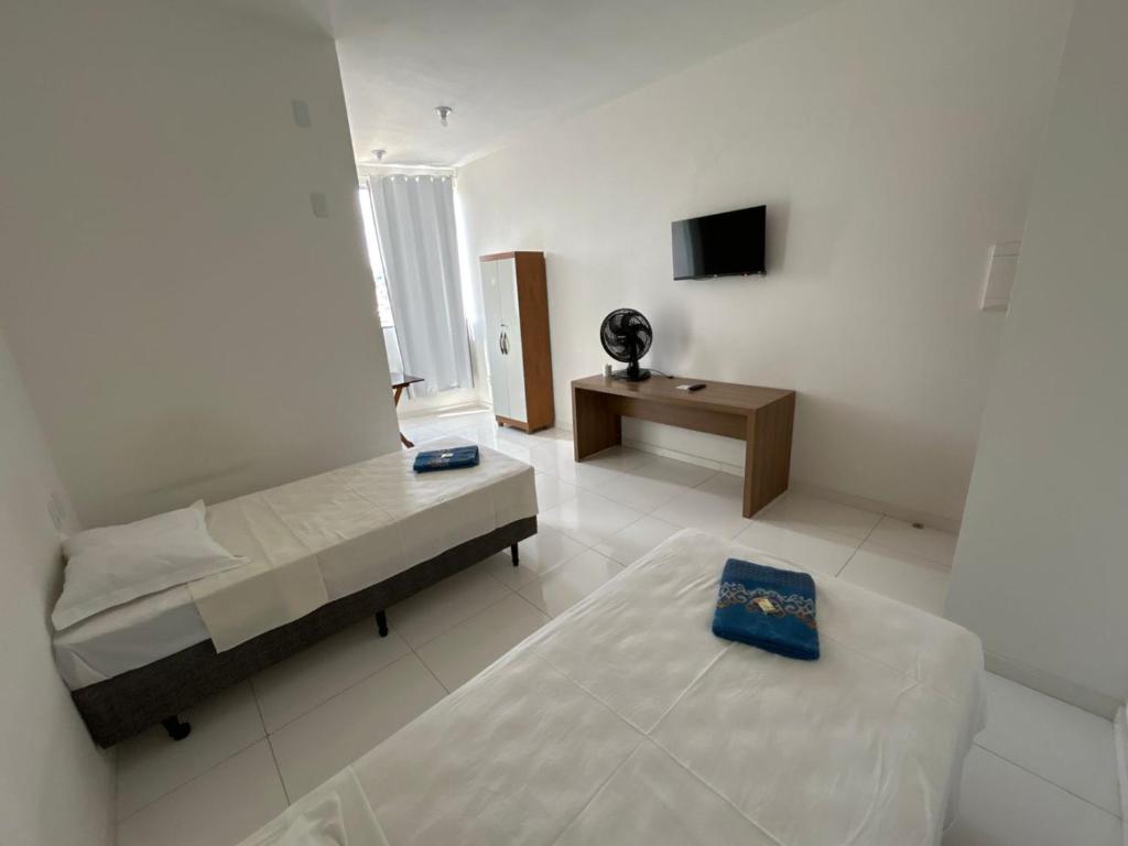 パラ・デ・ミナスにあるShalom Flat Hotelのベッドルーム(ベッド2台、テレビ付)