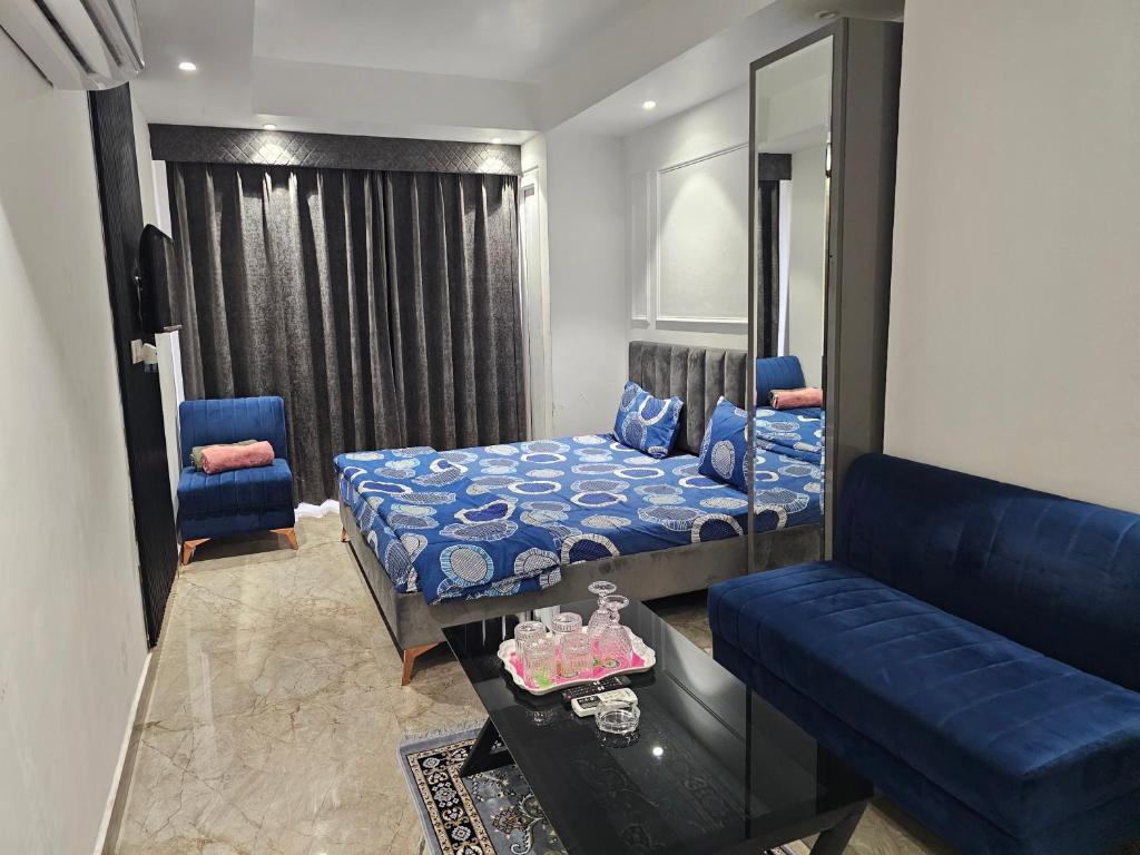 a bedroom with a bed and a couch and a mirror at Ultra Luxury Apartment 814 By Bliss Stay in Zirakpur