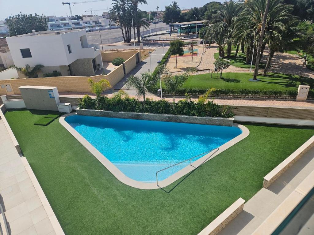 eine Draufsicht auf einen Swimmingpool und Gras in der Unterkunft San Pedro Del Pinatar Penthouse in San Pedro del Pinatar