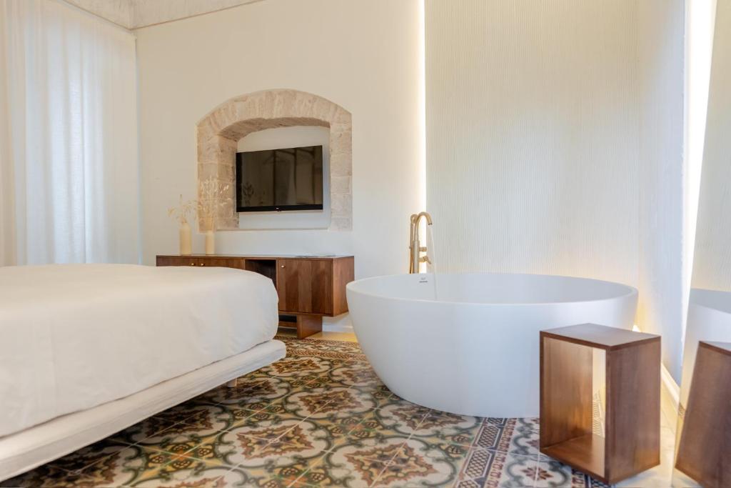a bathroom with a large tub and a sink at Garibaldi Luxury Suites in Noci