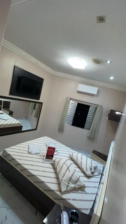 a bedroom with a bed with a mirror and a tv at Hotel rebeka in São Paulo