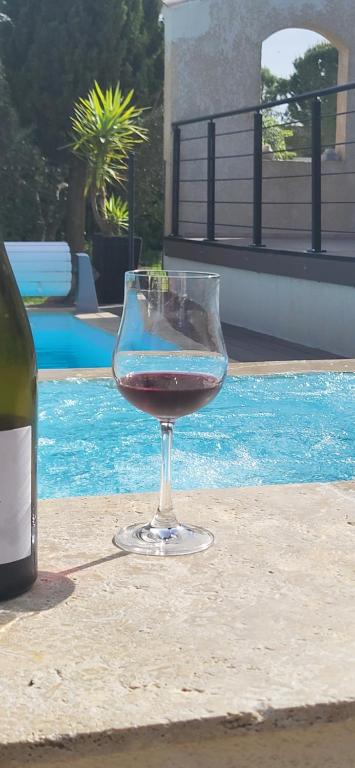 - un verre de vin assis à côté d'une bouteille dans l'établissement Villa Piscine vue dégagée, à Montaren-et-Saint-Médiers