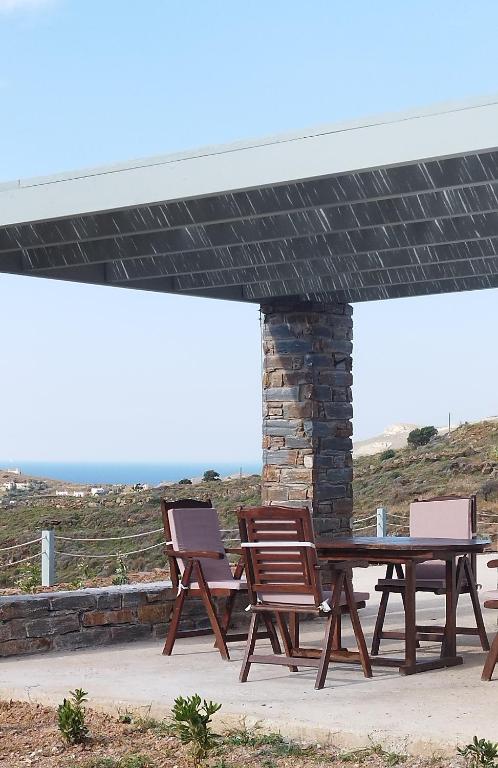 a picnic table and two chairs under a pavilion at Anesis in Ioulida