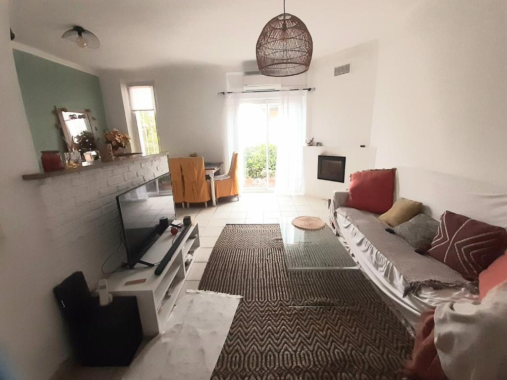 un salon avec un canapé et une télévision dans l'établissement Charmante maison de ville, à Grasse