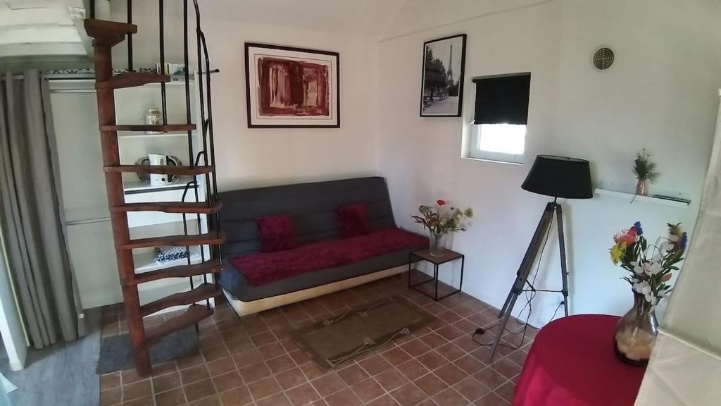 - un salon avec un canapé rouge dans l'établissement Maisonnette cocoon proche de l'aéroport d'Orly, à Paray-Vieille-Poste