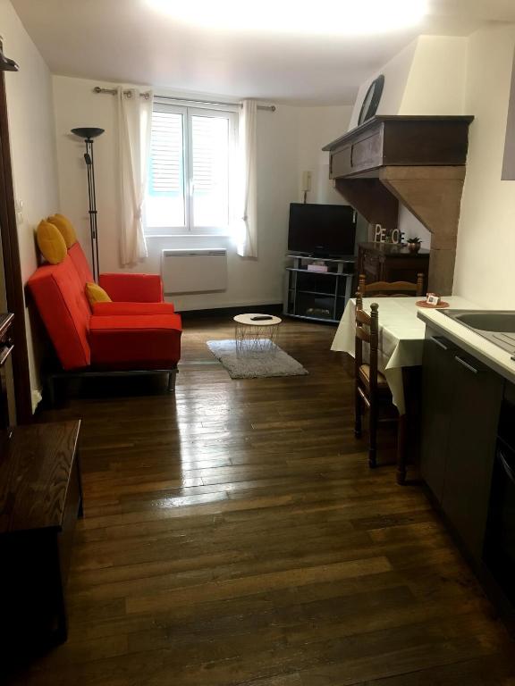 un salon avec un canapé rouge et une cuisine dans l'établissement Joli Appartement T2, à Saint-Jean-Pied-de-Port