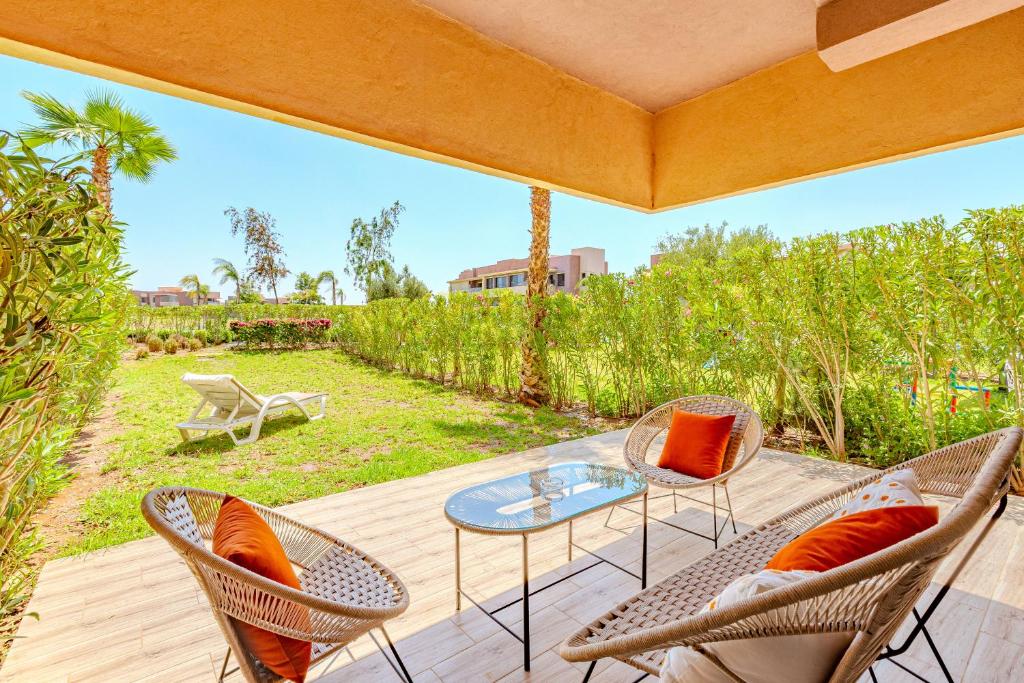 eine Terrasse mit einem Glastisch und Stühlen auf einer Terrasse in der Unterkunft Luxury apartments prestigia in Marrakesch