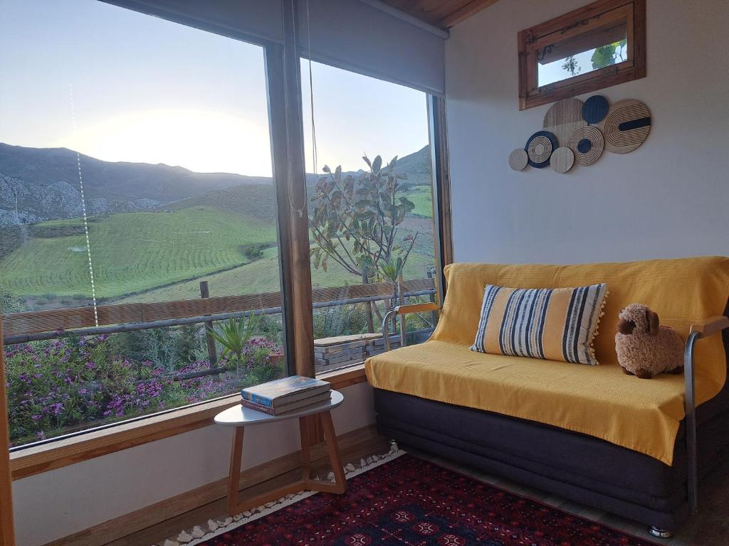 a room with a couch and a large window at Wooden House at the Mountain-private in Paránimfoi