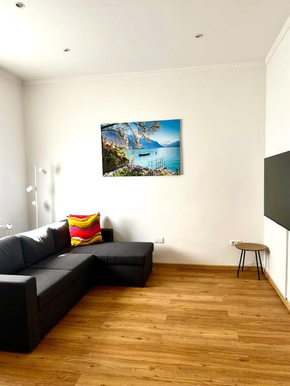 a living room with a black couch and a table at Wohnung nahe Flughafen Hamburg in Norderstedt
