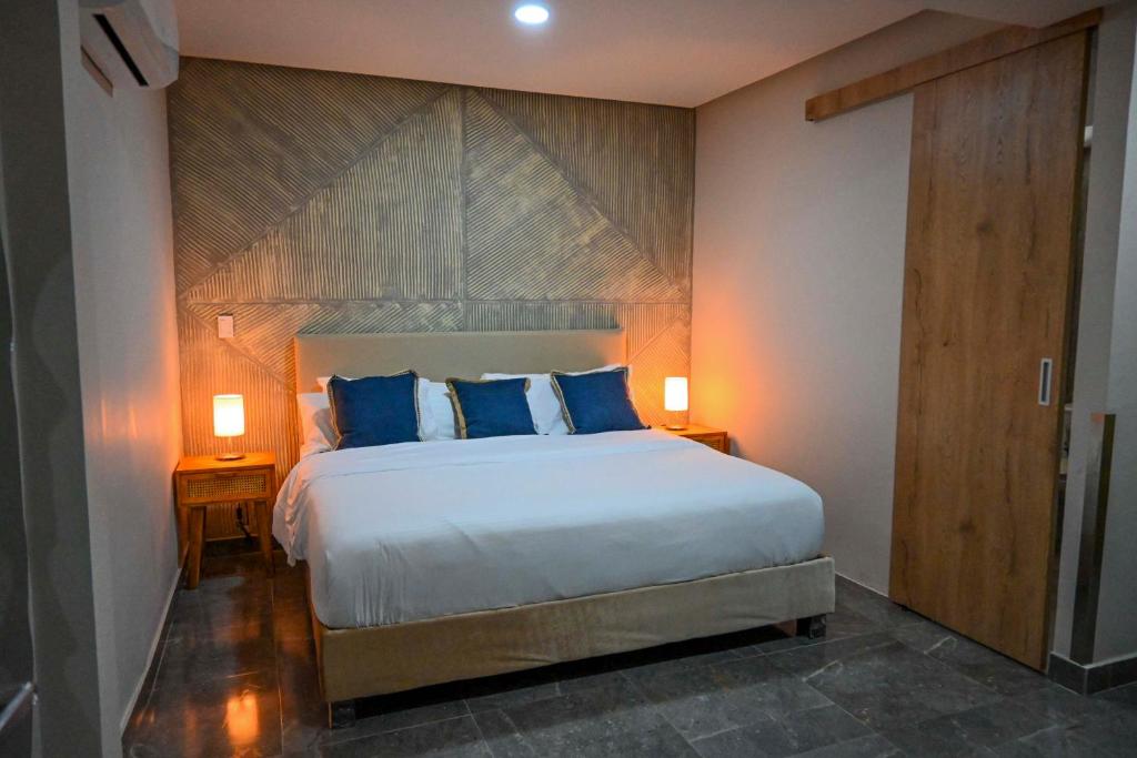 a bedroom with a large bed with blue pillows at Hotel Bahía Azul Manga Cartagena in Cartagena de Indias