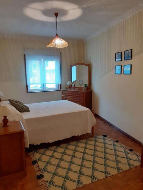 a bedroom with a bed and a window and a mirror at Ancora beira-mar in Vila Praia de Âncora
