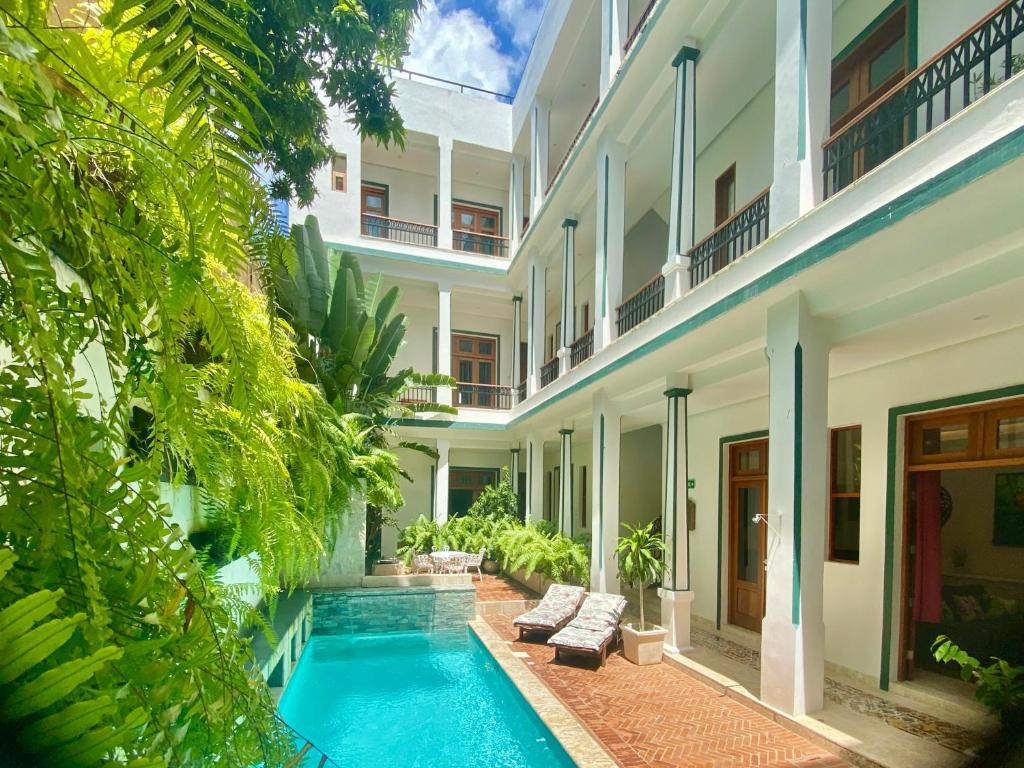 an exterior view of a building with a swimming pool at Boutique Hotel Casa Grande, Tropical Journey, Suite familiar de 2 dormitorios in Santo Domingo