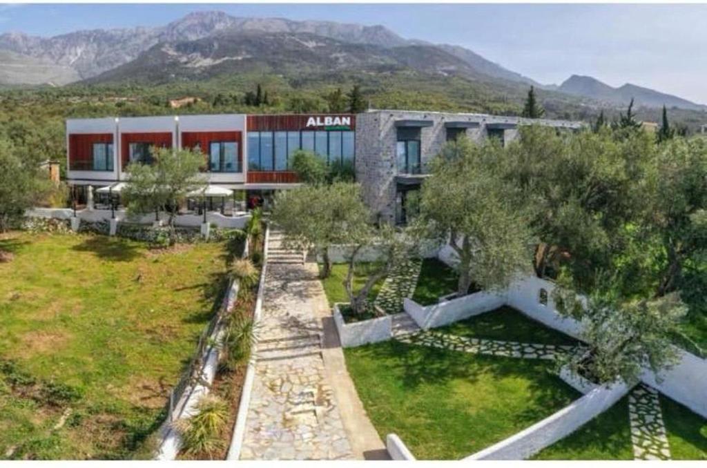 an aerial view of a building with mountains in the background at Alban Eco Hotel in Dhërmi