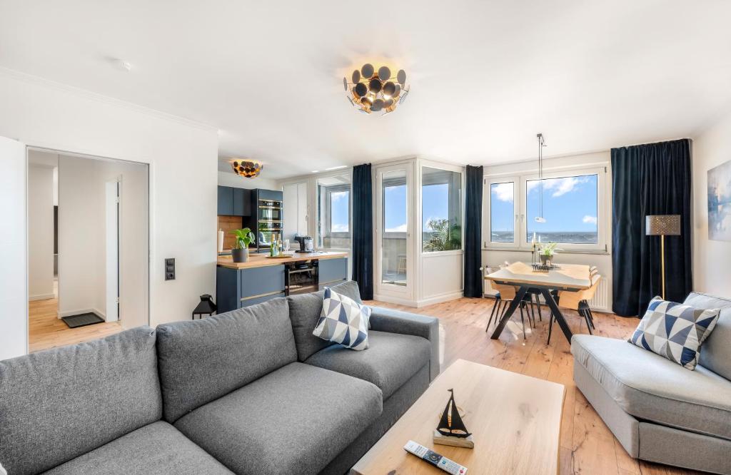un soggiorno con un divano e un tavolo di Exklusives Apartment Sunrise mit Whirlpool, Pool und Sauna a Bremerhaven