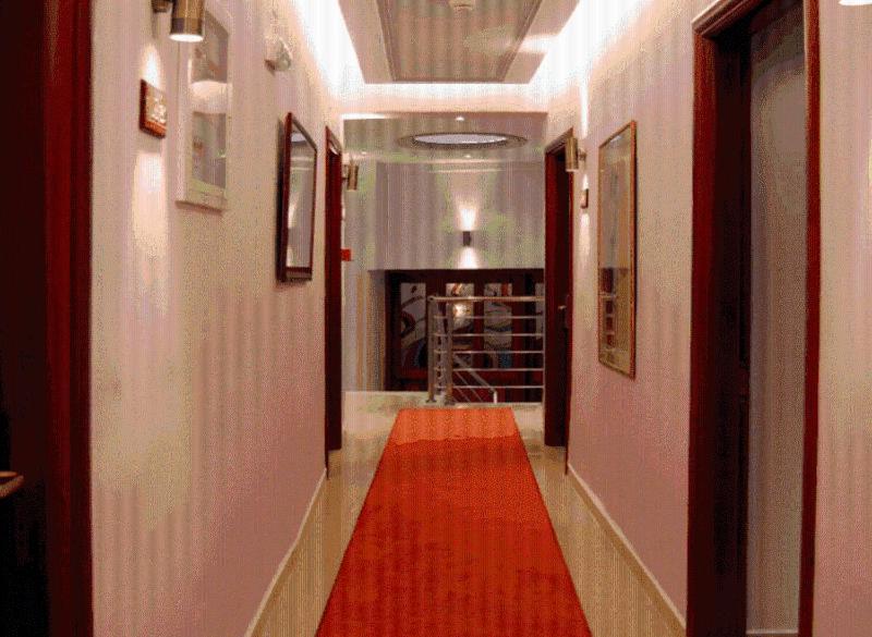 a hallway with a red rug and a hallway with a red carpet at Hotel Avra in Kardítsa