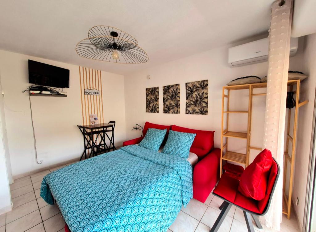 - une chambre avec un lit rouge et un canapé rouge dans l'établissement Studio Lucia - Vue mer, à Saint-Aygulf
