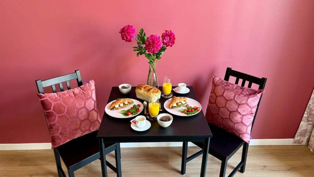 - une table avec de la nourriture et des boissons ainsi qu'un vase avec des fleurs dans l'établissement Rubis de Promenade des Anglais, à Nice
