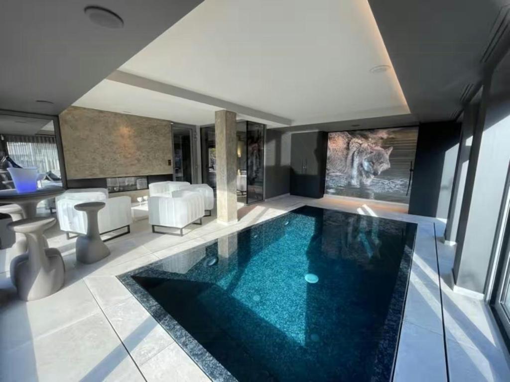 - une piscine dans une pièce avec une table et des chaises dans l'établissement Eco-Friendly House With Pool Near Lake Gérardmer, à Gérardmer