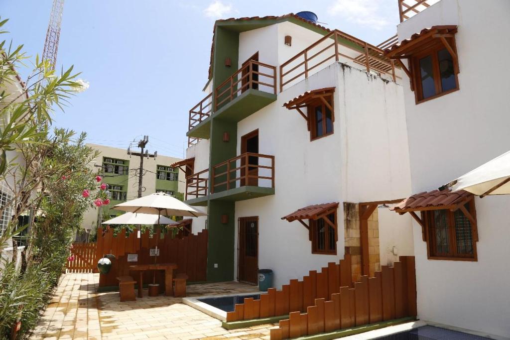 a building with balconies and a table and umbrella at Tamandaré Residence Beach 3 in Tamandaré