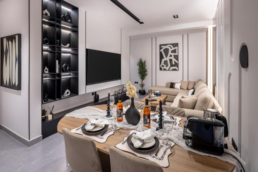 a living room with a table and a couch at Delmar Luxury 3BR Apartment 4 in Jeddah