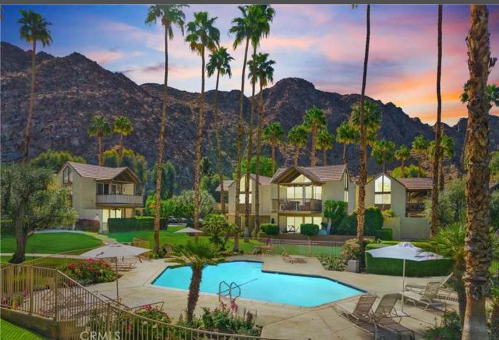 Indian Wells Mtn Cove with Kitchen Living Room Patio Firepit BBQ Tennis Stadium في إينديان ويلس: منتجع مع حمام سباحة وأشجار النخيل