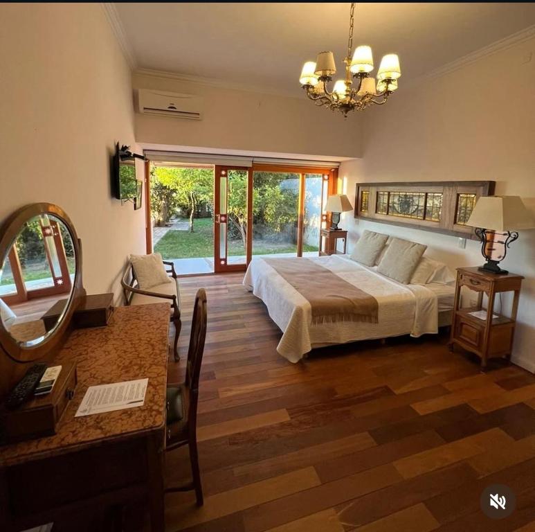 a bedroom with a bed and a table and a mirror at Casa Crespo Hotel Boutique in Patagones