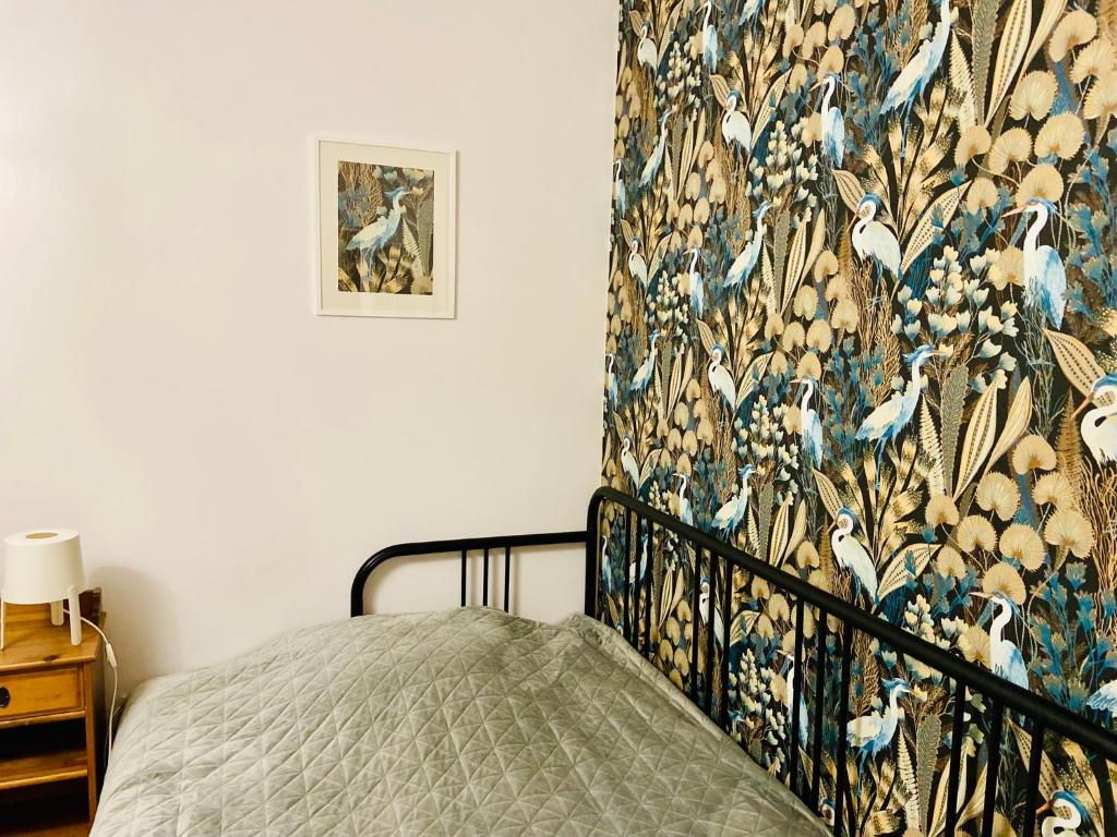 een slaapkamer met een bed met een bloemenbehang bij Czaple na Muchoborze by Apartamenty na dni Wrocław in Wrocław