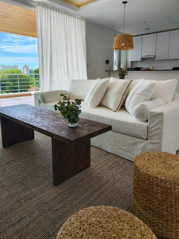 a living room with a white couch and a table at Depto 2 Dorm en Posadas - Lomas de Alem in Posadas