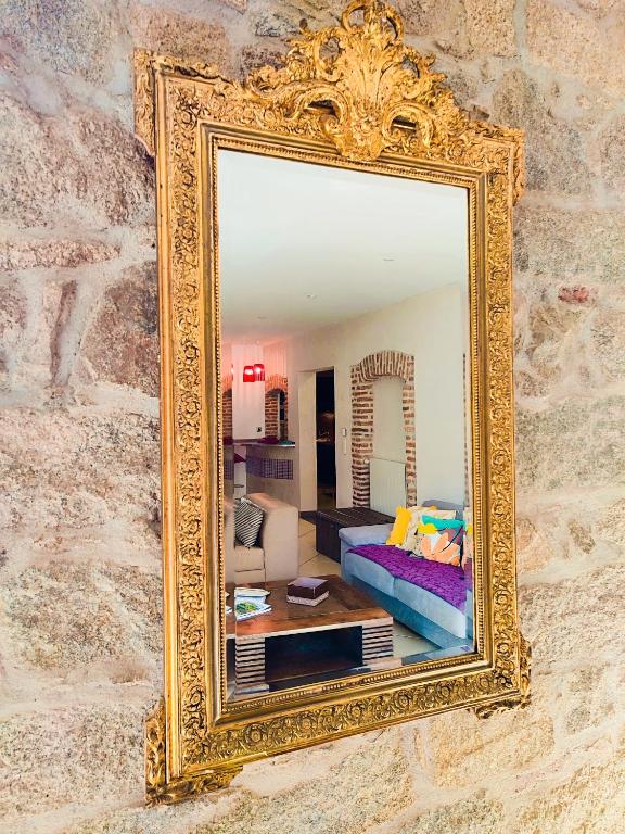 un miroir en or suspendu sur un mur avec un salon dans l'établissement T3 de 140m2 pour 7 pers- Extra centre Ajaccio - À 5 min à pied des plages - Classé 5 étoiles - CASA DI ARTISTI, à Ajaccio
