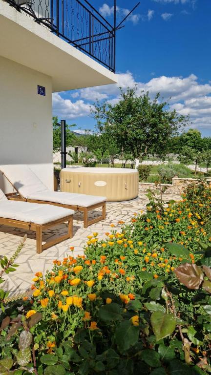 a patio with two benches and a bunch of flowers at Villa Dona Bella in Donji Bitelić