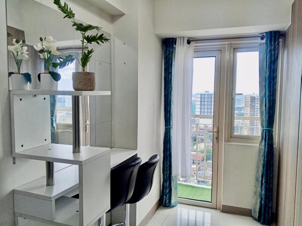 a room with a desk and chairs and a window at Jessa Rios Coast Staycation in Manila