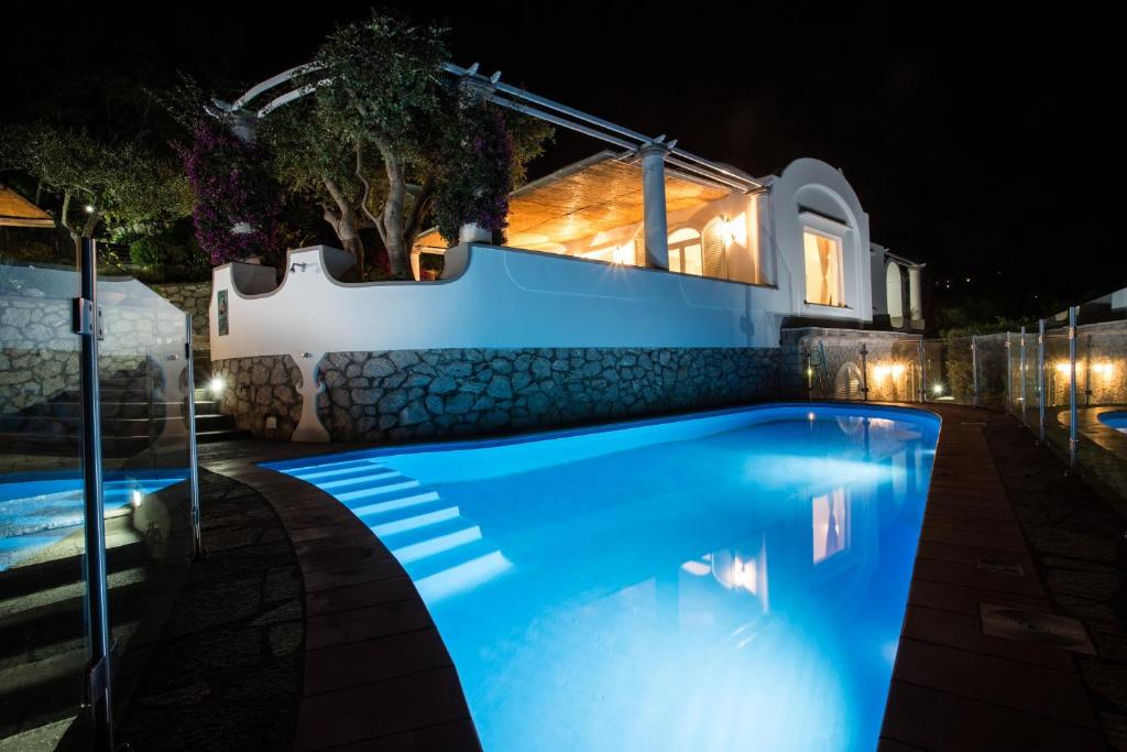 una piscina di fronte a una casa di notte di Villa Mascia ad Anacapri