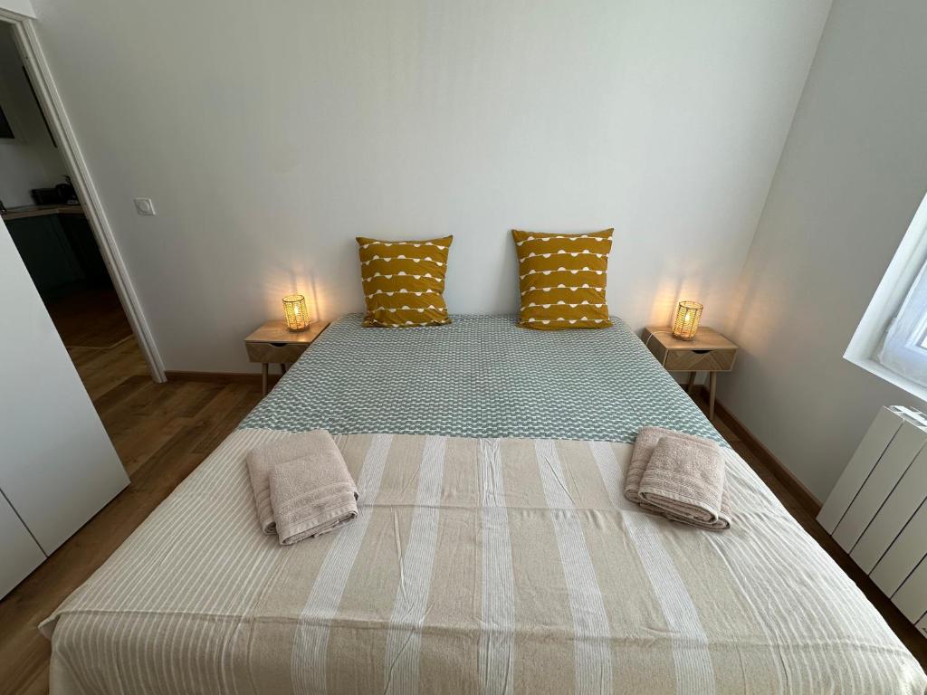 a bedroom with a large bed with two pillows at Chez Camille & Emma - Hyper Centre Climatisé in Rochefort
