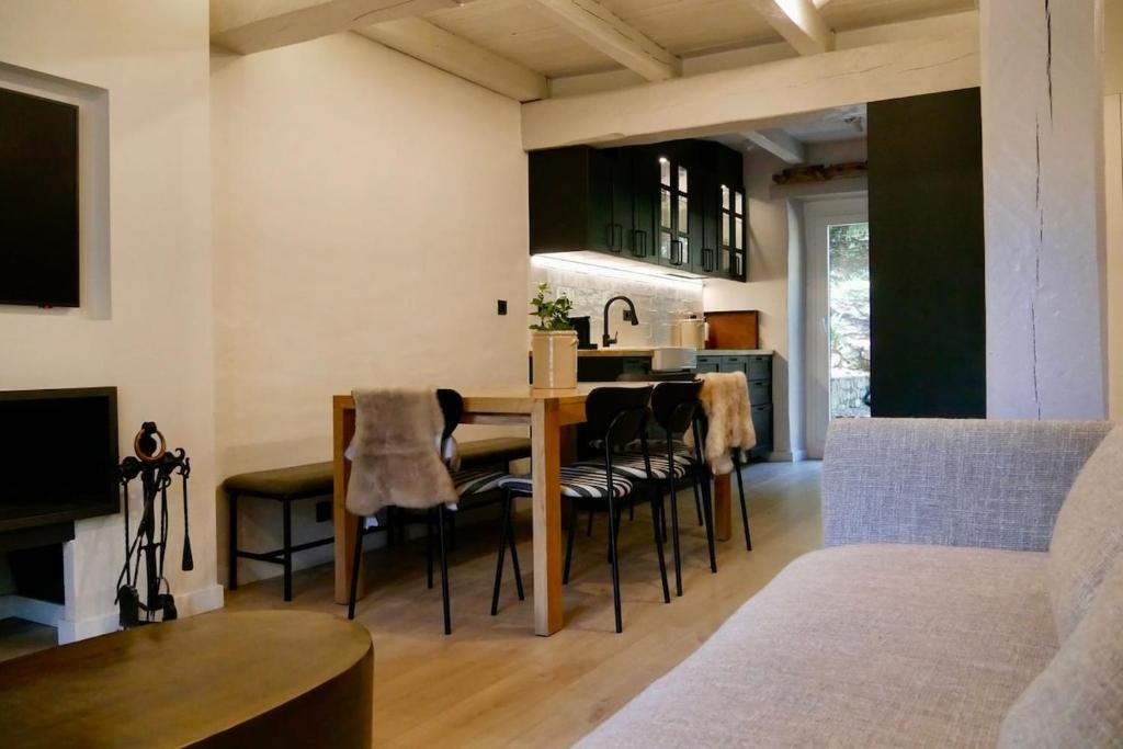 een keuken en woonkamer met een tafel en stoelen bij Arties Lodge in Arties