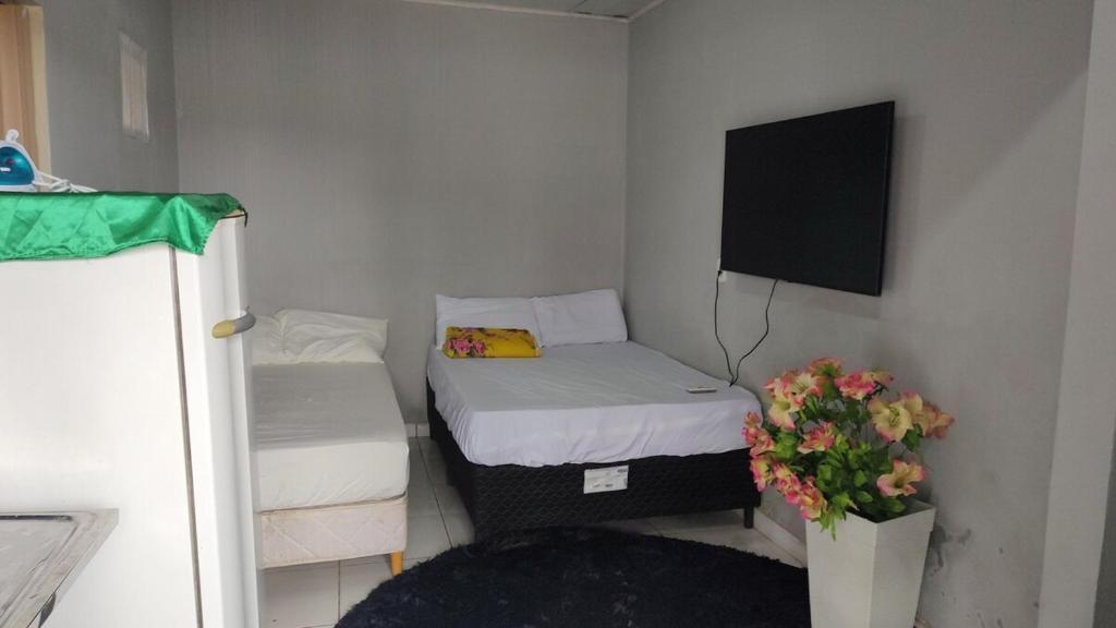 a small room with two beds and a tv at Apto privativo in Rio Branco