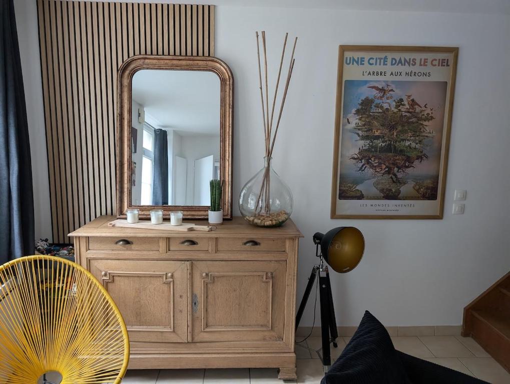 un miroir au-dessus d'une commode dans une pièce dans l'établissement Maison agréable au coeur de Bayeux !, à Bayeux